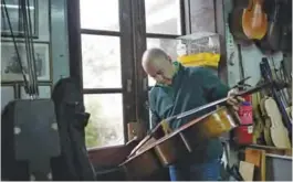  ??  ?? Joaquim Capela inspects a cello at the Capela workshop in Espinho, northern Portugal.