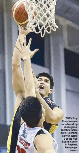  ?? PBA IMAGE ?? TNT’s Troy Rosario soars for a tear-drop shot against Ginebra rookie Arvin Tolentino early in Game 3 at the AUF Sports Center in Angeles, Pampanga.