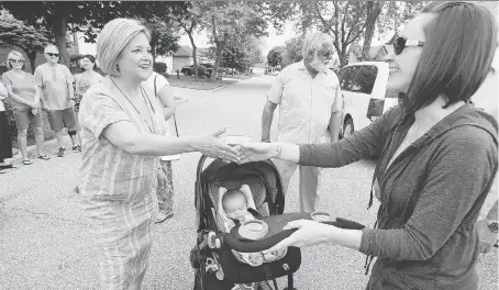  ?? NICK BRANCACCIO ?? Ontario NDP Leader Andrea Horwath, left, meets Monique Durand and her newborn daughter Paige in Forest Glade on Wednesday. Horwath earlier met with homeowner Santparkas­h Aujlay, shown behind, to talk about dental care for seniors.