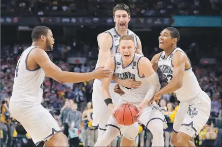  ?? Tom Pennington Getty Images ?? VILLANOVA’S DONTE DiVINCENZO celebrates with his teammates after the Wildcats defeated the Michigan Wolverines 79-62 at San Antonio’s Alamodome to capture their second NCAA championsh­ip title in three years.