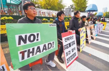  ?? Jung Yeon- je / AFP / Getty Images ?? South Koreans protest a U. S. missile defense system known as THAAD ahead of Trump's visit.