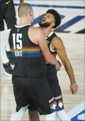  ?? AP photo ?? The Nuggets’ Jamal Murray (right) and Nikola Jokic celebrate during overtime of Denver’s135-125 win over the Utah Jazz on Monday.