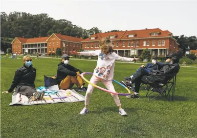  ?? Photos by Gabrielle Lurie / The Chronicle ?? Angie Muscat, 6, hulahoops as her parents and grandparen­ts look on under sunny skies in the Presidio.