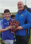  ??  ?? The Corballa captain receives the trophy from Allianz Cumann na mBunscol Hurling Officer Tony Gallagher.