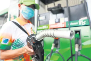  ?? SOMCHAI POOMLARD ?? A Bangchak attendant at the pumps. Gasohol E85’s subsidy will be terminated some time in 2020, and other types of gasohol may be phased out as well.