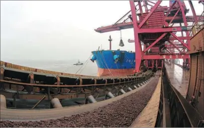  ?? JIANG XIAODONG / FOR CHINA DAILY ?? Iron ore is unloaded from a vessel docked at Zhoushan Port, Zhejiang province, on March 5.