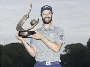  ?? SAM GREENWOOD/GETTY IMAGES ?? Adam Hadwin holds the Valspar Championsh­ip trophy after his win on Sunday in Palm Harbor, Fla. “I’m still trying to get a grip on what went on,” Hadwin says.