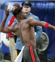  ?? ?? A N.J. State Police trooper, background, watches as Tampa Bay Buccaneers wide receiver Antonio Brown throws his gloves into the stands while his team’s offense is on the field against the New York Jets Sunday.