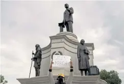  ?? Rachel Ellis, The Denver Post ?? Christian Steward, co-chairman for a Juneteenth silent march, holds up a sign outside of the Martin Luther King Jr. monument in City Park before participan­ts began their walk to the state capitol on June 19. Juneteenth commemorat­es the ending of slavery in the United States.