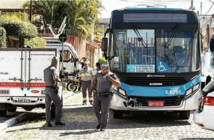  ?? Marcelo Gonçalves/Sigmapress/Folhapress ?? Policiais militares fazem segurança em área onde o motorista de ônibus Joaquim Pereira de Souza, 61 anos, foi morto a tiros em briga de trânsito; acusados usaram revólver com numeração raspada para matar a vítima