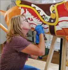  ?? Visit Buffalo Niagara ?? Artist Linda Chaffee of Akron, N.Y., paints a horse for the Buffalo Heritage Carousel in Buffalo, N.Y.