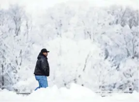  ?? MATT ROURKE/AP ?? A motorist walks to a rest stop in Hershey, Pa., on Jan. 8. More snow is forecast for parts of Pennsylvan­ia by Saturday.