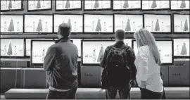  ?? Justin Sullivan Getty Images ?? WORKERS look at Haier television­s at the 2010 CES in Las Vegas. Next week’s event is expected to see TV makers pushing 8K to combat the falling prices of 4K.