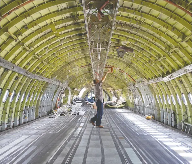  ?? Christinne Muschi / REUTERS ?? The curtailmen­t of air travel during the pandemic is good news for companies that recycle retired aircraft, like Aerocycle in Mirabel, Que.