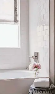  ?? Max Burkhalter ?? A contempora­ry bathroom makeover with white tile, frameless glass shower and crisp white window shades gets your home ready to sell.