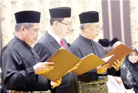  ??  ?? From right: Home Minister Tan Sri Muhyiddin Yassin, Finance Minister Lim Guan Eng and Defence Minister Mohamad Sabu reading their oath of office, loyalty and secrecy before the Yang di-Pertuan Agong Sultan Muhammad V at Istana Negara yesterday.