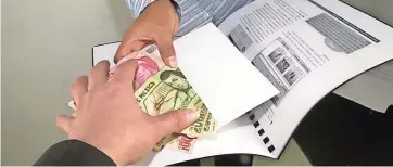  ??  ?? UNA Persona pone dinero sobre un documento