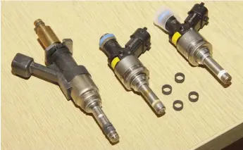  ??  ?? From right to left: new 997 injector, showing white Teflon stem seal; a used injector from the affected engine, showing discolouri­ng, and staining of stem; BMW injector, with two grey graphite-based seals