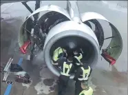  ?? PROVIDED TO CHINA DAILY ?? Maintenanc­e personnel from China Southern Airlines check an aircraft engine after a handful of coins were tossed toward it in Shanghai on Tuesday.