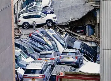  ?? Mary Altaffer/ Associated Press ?? Cars are piled on top of each other after a partial collapse of a parking garage in the Financial District of New York City on April 18.