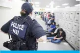  ??  ?? This image released by the US Immigratio­n and Customs Enforcemen­t (ICE) shows a Homeland Security Investigat­ions (HSI) officer guarding suspected illegal aliens. — AFP