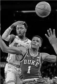  ?? Andres Kudacki / AP ?? St. John’s point guard Shamorie Ponds (back) passes the ball over Duke’s Trevon Duval during the first half of Saturday’s game at Madison Square Garden in New York.