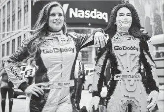  ?? BEBETO MATTHEWS THE ASSOCIATED PRESS ?? Danica Patrick, left, poses with a life-size Lego statue creation of herself in New York on Tuesday. Lego master builder Chris Steininger says it took him 200 hours to build, using under 15,000 pieces and 13 colours.