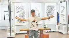  ??  ?? Huang Yifei posing with his artworks