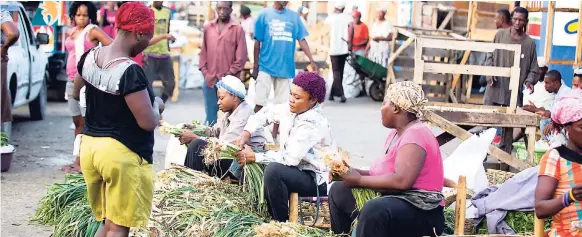  ?? AP PHOTOS ?? In this July 18, 2018 photo, vendors sell leeks at the Croix des Bossalles market in Port-au-Prince, Haiti. The cost of living seems like it is spiralling out of control to many Haitians, making life even more of a struggle in the most impoverish­ed...