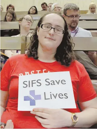  ?? STAFF PHOTOS BY ANGELA ROWLINGS ?? TREATMENT IS AN OPTION: Aubri Esters, a drug user who overdosed last week, holds a sign yesterday during a hearing at Boston City Hall to show her support for safe injection facilities.