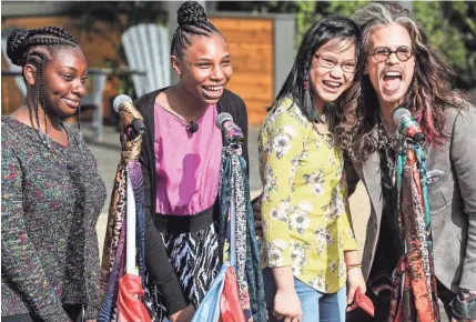  ??  ?? From left, Sylvia, Jabrayia, Jenna and Steven Tyler pose for photos during a scarf-cutting celebratio­n Monday outside of Janie’s House at Youth Villages in Bartlett. PHOTOS BY BRAD VEST/THE COMMERCIAL APPEAL