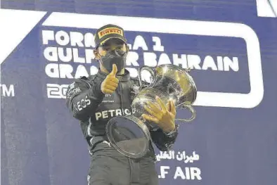  ?? EFE / VALDRIN SHEMAJ ?? Lewis Hamilton levanta el dedo pulgar en el podio del primer gran premio de la temporada.