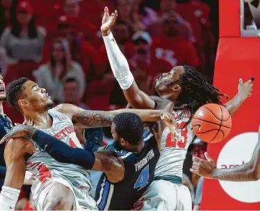  ?? Brett Coomer photos / Staff photograph­er ?? Memphis guard Raynere Thornton (4) has a shot blocked by UH forward Breaon Brady, left, while driving to the basket between Brady and UH forward Cedrick Alley Jr. during the first half Sunday.