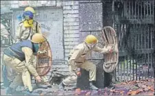  ??  ?? Police personnel take cover near a college in Lal Chowk as students hurl stones at them in Srinagar on Monday.