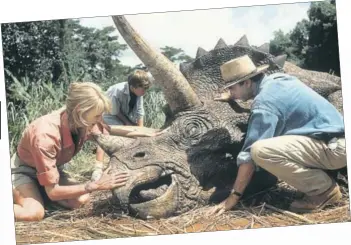  ?? GETTY IMAGES ?? Laura Dern and Sam Neill come to the aid of a Triceratop­s in a scene from the first Jurassic Park film.