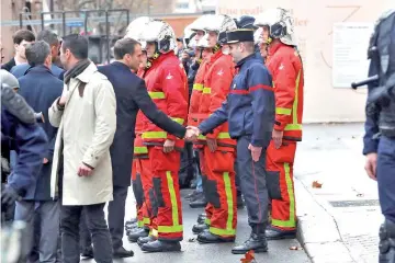  ??  ?? Macron shakes hand with a firefighte­r as he visits firefighte­rs and riot police officers the day after a demonstrat­ion, in Paris. — Reuters photo