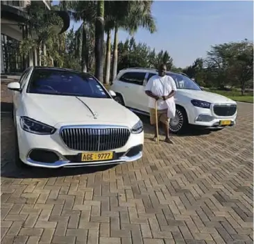  ?? ?? Extravagan­t ... Madzibaba Wicknell Chivayo poses next to some of his luxurious cars.