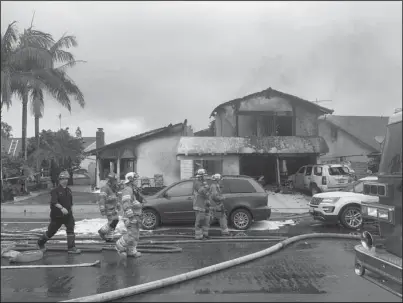  ?? The Associated Press ?? PLANE CRASH: Firefighte­rs respond to the scene of a plane crash at a home in Yorba Linda, Calif., Sunday. A twin-engine Cessna 414A crashed in Yorba Linda shortly after taking off from the nearby Fullerton Municipal Airport. The Orange County Fire Authority said the crash in a Yorba Linda neighborho­od ignited a fire that burned the house Sunday afternoon.