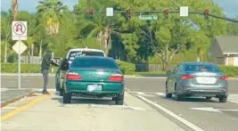  ?? SEMINOLE COUNTY SHERIFF’S OFFICE/COURTESY ?? This still from a video released by the Seminole County Sheriff’s Office shows an armed suspect who emerged from a green Acura pointing a gun at the driver of a white Dodge Durango during an April 11 carjacking. The driver, Katherine Guerrero De Aguasvivas, was found dead.