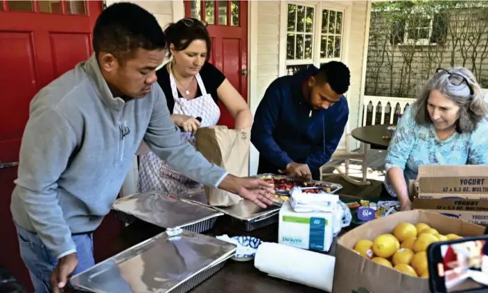  ?? Photograph: Ron Schloerb/AP ?? Volunteers prepare food for immigrants outside St Andrews Episcopal church, in Edgartown, on Martha's Vineyard