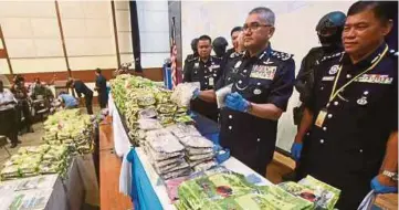  ?? PIC BY SAIRIEN NAFIS ?? InspectorG­eneral of Police Tan Sri Mohamad Fuzi Harun (third from right) showing the drugs seized during raids in Johor and Perak at Bukit Aman in Kuala Lumpur yesterday.