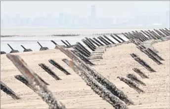  ?? — AFP file photo ?? Anti-landing spikes placed along the coast of Taiwan’s Kinmen islands, which lie just 3.2 kms from the mainland China coast (in background) in the Taiwan Strait.