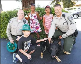  ?? PHOTOS BY GARY REYES — STAFF PHOTOGRAPH­ER ?? Santa Clara County Sheriff Deputy Rick Chaeff, left and Sgt. Jeremy Jones show off “Raider” to Isys Robinson, 7, Ziggy Robinson, 5, and Damarrion Brown, 7, at the Goodies Cafe in Campbell on Friday.