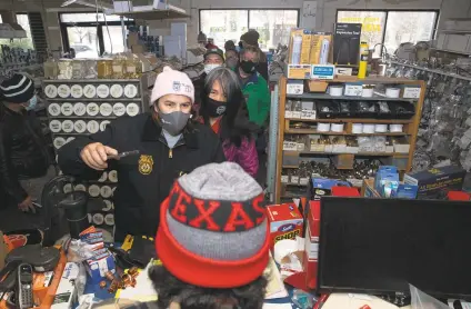  ?? Yi-Chin Lee / Staff photograph­er ?? People wait in line at U-Plumb-It to purchase materials to for pipe repairs. Receipts were done manually because of a power outage.