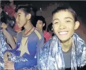  ??  ?? In this July 3 image taken from video provided by the Royal Thai Navy Facebook Page, a Thai boy smiles as Thai Navy SEAL medics help injured children inside a cave in Mae Sai, northern Thailand.