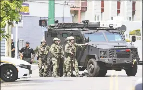  ?? Arnold Gold / Hearst Connecticu­t Media ?? New Haven Police wait behind an armored vehicle in the aftermath of a hostage situation in New Haven on June 4.