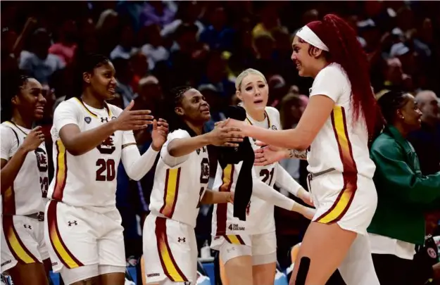  ?? GREGORY SHAMUS/GETTY IMAGES ?? The South Carolina bench was waiting for Kamilla Cardoso (right) when she checked out after registerin­g 15 points and 17 rebounds.