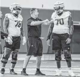  ?? AL DIAZ adiaz@miamiheral­d.com ?? Hurricanes head coach Mario Cristobal, center, says of offensive tackle Markel Bell (70), who is nearly 6 feet 9 inches tall: ‘It’s not just the size. It’s the athleticis­m.’