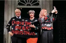  ?? Photo: Getty ?? An employee at Madame Tussauds in London takes a selfie with wax figures depicting Britain’s Foreign Secretary Boris Johnson, left, and Prime Minister Theresa May wearing a Christmas jumper.