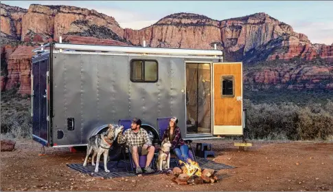  ?? JOHN BURCHAM / THE NEW YORK TIMES ?? Nicoll Davis and her husband, Jake, with their three dogs Feb. 8 in Sedona, Ariz. They now feel trapped in the cargo trailer, although it was once their dream home. “When the pandemic began, our tiny home started to feel a whole lot smaller,” she said.